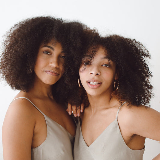 two beautiful black girls with low porosity curly afro hair